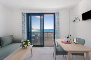 a living room with a table and a view of the ocean at Apartamentos Playa Azul - 9 in Vallehermoso +19 photos