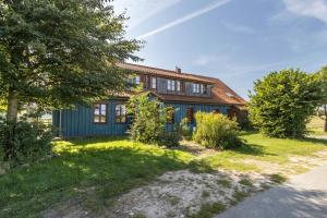 a home with a blue house with a yard at Apartment Lüneburger Heide in Hankensbüttel