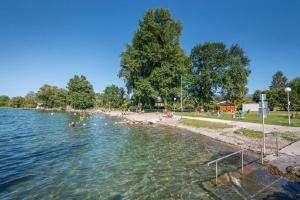 a body of water with people swimming in it at Chalet 35m2 3 chambres in Sciez