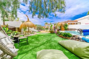 a backyard with a green lawn and a swimming pool at Oceania Villa Private Pool Garden in Chayofa