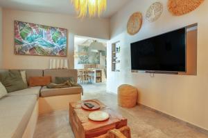 a living room with a couch and a flat screen tv at Oceania Villa Private Pool Garden in Chayofa
