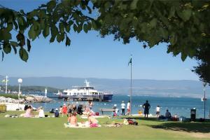 a group of people on the beach with a boat in the water at Chalet 35m2 3 chambres in Sciez