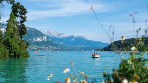 a lake with people in a boat on the water at Chalet 35m2 3 chambres in Sciez