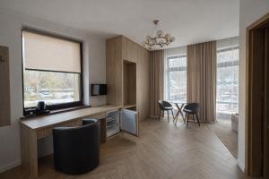 a living room with a desk and chairs and a window at Willa Deptak in Krynica Zdrój
