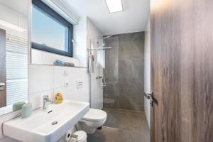 a bathroom with a sink and a toilet and a window at Ferienhaus Sonnenwind Hainer See Og in Neukieritzsch +16 photos