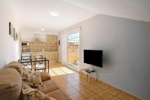 a living room with a couch and a television at Montemar 1 in Moya