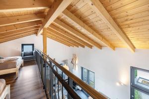 a living room with wooden ceilings and a staircase at Ferienhaus Sonnenwind Hainer See Og in Neukieritzsch
