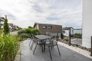 a table and chairs on the patio of a house at Ferienhaus Sonnenwind Hainer See Og in Neukieritzsch