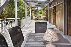 a porch with a lamp and a table and chairs at Ferienwohnung Donautal in Meßkirch