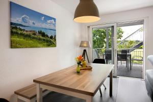 a living room with a wooden table and a view of a balcony at Ferienwohnung Donautal in Meßkirch