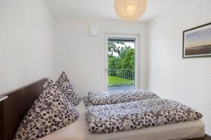 a bedroom with two beds and a window at Ferienwohnung Donautal in Meßkirch