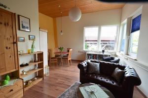 a living room with a leather couch and a table at Fewo Heym in Suhl