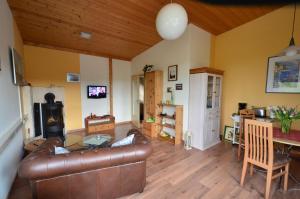 a living room with a leather couch and a table at Fewo Heym in Suhl