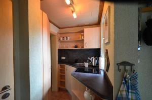 a small kitchen with a black counter and a sink at Fewo Heym in Suhl +2 photos