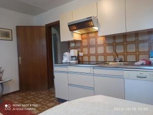 a kitchen with white cabinets and a sink at Apartement Jörg in Lana