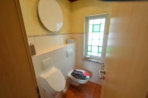 a small bathroom with a toilet and a window at Fewo Heym in Suhl