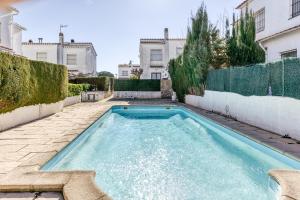 a swimming pool in the backyard of a house at Villa La Flor con piscina in L'Escala