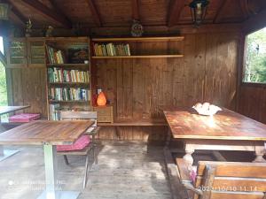 a room with two wooden tables and a book shelf at Apartement Jörg in Lana