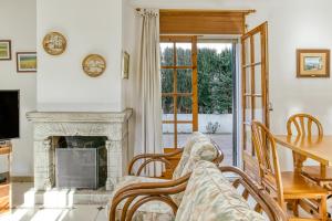 a living room with a fireplace and a table at Villa La Flor con piscina in L'Escala