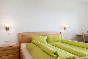a bedroom with two green pillows on a bed at Forchnerhof Apt Ploseblick in Maranza