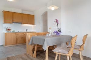 a kitchen with a table and chairs in a room at Forchnerhof Apt Ploseblick in Maranza