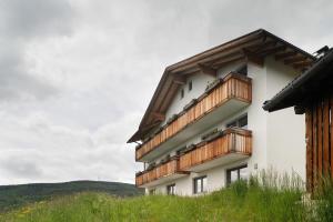 a building with wooden balconies on the side of it at Forchnerhof Apt Ploseblick in Maranza
