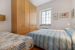 a bedroom with two beds and a large window at Via Colombo 12 Bilo in Bonassola
