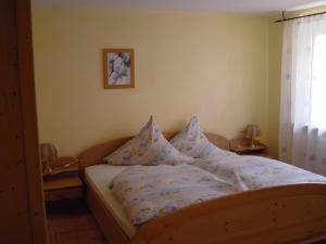 a bed with pillows on it in a bedroom at Ferienhof Roller in Simmersfeld