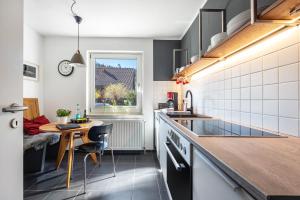a kitchen with a small table and a window at Waldgästehaus Externsteine in Horn-Bad Meinberg