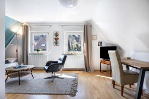 a living room with a desk and a table and chairs at Waldgästehaus Externsteine in Horn-Bad Meinberg