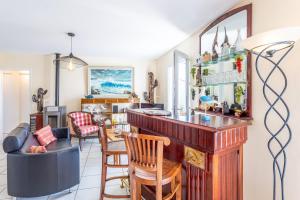 a kitchen with a bar and a living room at Maison Salorge - piscine privée in Jard-sur-Mer