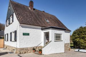 a white building with a brown roof at Waldgästehaus Externsteine in Horn-Bad Meinberg