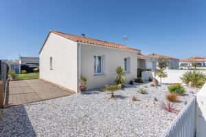 a white house with a fence and some plants at Maison Salorge - piscine privée in Jard-sur-Mer