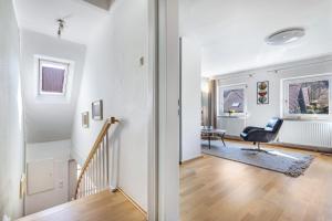 a living room with white walls and a stairway at Waldgästehaus Externsteine in Horn-Bad Meinberg