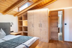 a bedroom with a bed and a wooden ceiling at Schreiberhof Charme in Laion