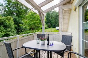 a table and chairs on a porch with a bottle of wine at Beutenmühle Straussenfarm Dach in Owingen