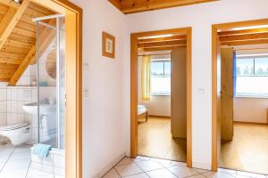 a bathroom with a toilet and a glass door at Beutenmühle Straussenfarm Dach in Owingen +30 photos