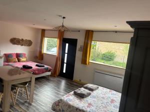 a living room with a bed and a table at L'Ambréenne in Sainte-Cécile