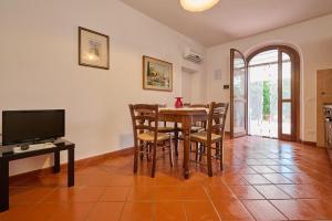 a dining room with a table and chairs and a television at Antichi Palmenti - Alloro in San Vincenzo