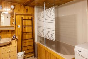 a bathroom with a tub and a window with blinds at Chalet D'alpage Authentique in Queige +13 photos