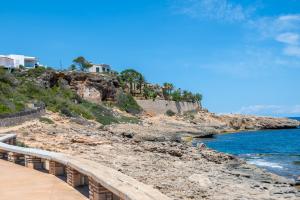 a bridge over the water next to a beach at Villa Juana Maria in Cala Murada