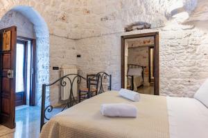 a bedroom with a bed in a stone wall at I Trulli di Dona Filomena in Selva di Fasano