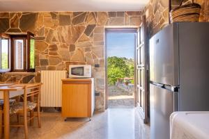 a kitchen with a refrigerator and a table with a microwave at I Trulli di Dona Filomena in Selva di Fasano +23 photos