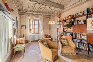 a living room with two chairs and bookshelves at Villa Gabriella - Piazzano in Lucca