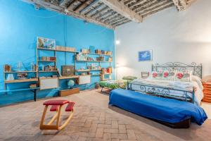 a bedroom with blue walls and a bed and a red stool at Villa Gabriella - Piazzano in Lucca