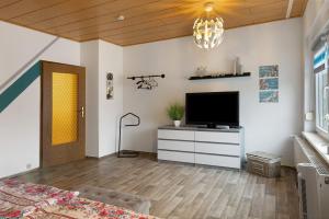 a living room with a television on a dresser at Haus Mari in Gommern