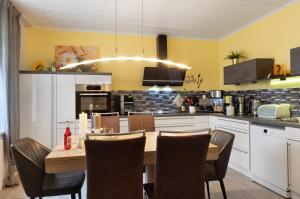 a kitchen with a wooden table and chairs in a kitchen at Haus Mari in Gommern
