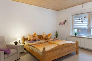 a bedroom with a bed and a chair and a window at Haus Mari in Gommern