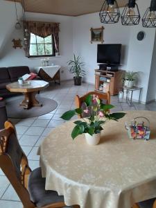 a living room with a table with flowers on it at Ferienwohnung Heinz Romes in Wimbach