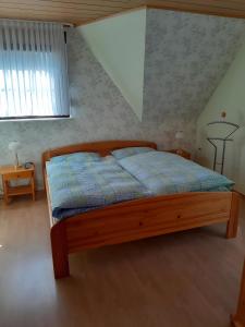 a bedroom with a bed with a blue comforter at Ferienwohnung Heinz Romes in Wimbach